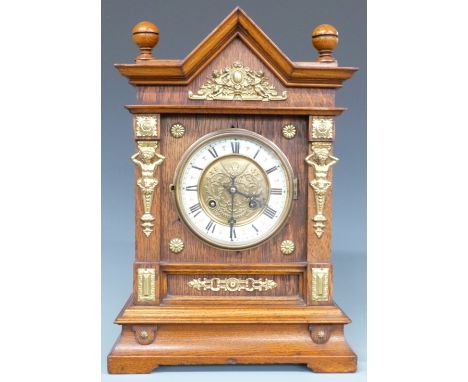 Architectural oak cased mantel clock with ivory coloured Roman chapter ring, brass decoration, pierced hands and two train mo