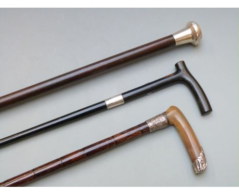 Three silver and white metal mounted walking canes, London 1924 the other two unmarked, one having horn handle