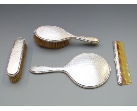 Walker and Hall four piece hallmarked silver dressing table set comprising hand mirror, two brushes and comb, Sheffield 1925/