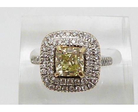 An 18ct white gold ring set with a cushion cut fancy yellow diamond of approximately 1.51ct&nbsp;surrounded by two rows of di