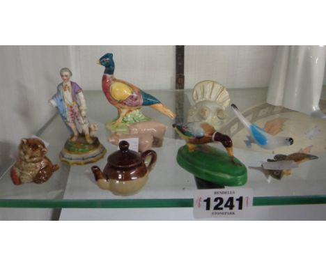 A quantity of small ceramic and glass figurines including Crown Staffordshire duck, worm, Wade pigs, etc.