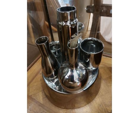 An unusual lustre metal effect ceramic table centrepiece with six integral containers of varying form including a cup, vase, 