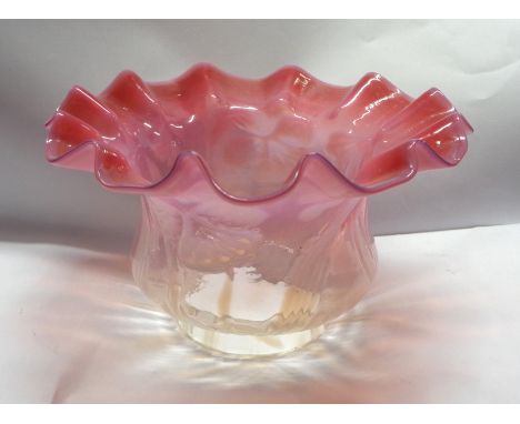 An early 20th Century cranberry and vaseline glass lamp shade with internal floral decoration and wavey rim