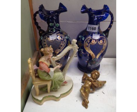 A pair of late 19th Century blue glass ewers with twist handles and enamel decoration - sold with a German porcelain figure, 