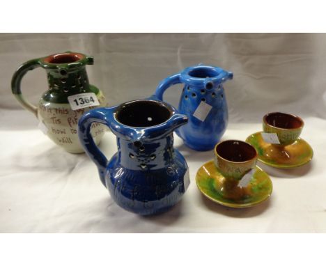 Five pieces of North Devon pottery comprising two Baron puzzle jugs, a Brannam similar and two Baron egg cups