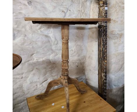 A 51cm old stripped pine tilt top pedestal table with oblong top, set on turned pillar and tripod base