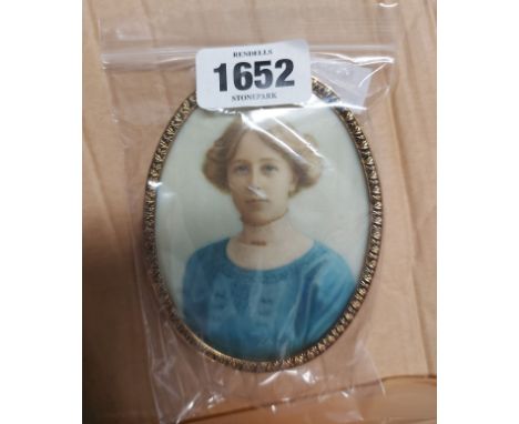 A gilt metal oval framed portrait miniature on ivory, depicting a lady wearing a blue dress - bearing label verso 'Florence A