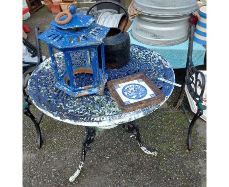 A decorative circular metal garden table, a pair of old metal bench ends, lantern, etc.
