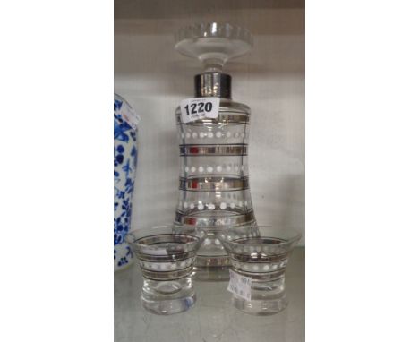 An Art Deco period decanter with silver plated rim with enamel and silver lustre banded decoration - sold with two liqueur gl