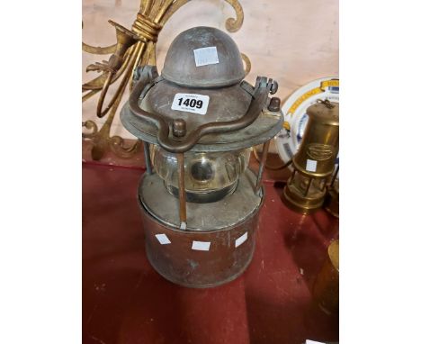 An old copper and metal ship's lantern with thick glass shade - crack to glass