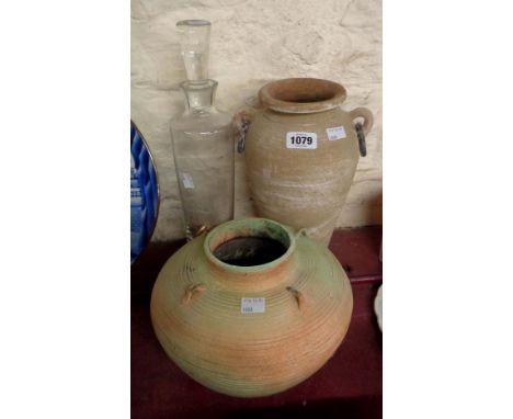 A turned ceramic pot with applied lug handles and painted finish - sold with another similar with iron loop handles and a gla