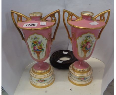 A pair of Mintons bone china vases of pedestal baluster with hand painted floral panels on a pink ground and gilt highlightin