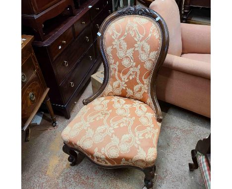 A Victorian stained walnut show-frame spoonback nursing chair with tapestry upholstery, set on cabriole front legs with white