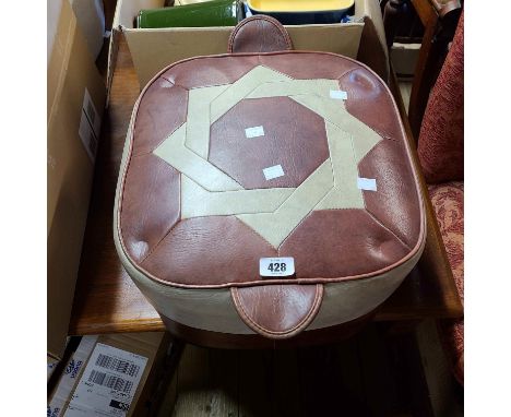 A vintage leather pouffe with star motif to top and red and grey finish