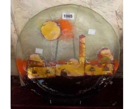 A Moroccan Art Glass plate with internal enamel decoration, depicting buildings under a large sun