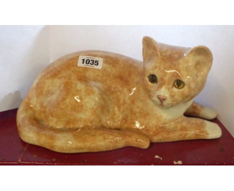 A large Winstanley Pottery figurine, depicting a ginger cat in recumbent pose, with hand painted finish