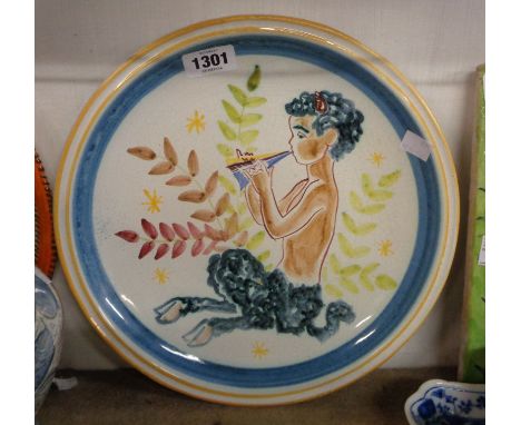 A vintage Terra Pottery Norway tin glazed charger with hand painted decoration, depicting a satyr playing the pipes