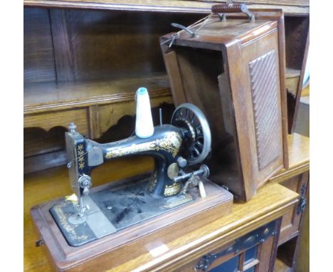 A SINGER MANUAL PORTABLE SEWING MACHINE, IN WOODEN CASE 