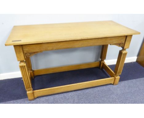A LIGHT OAK REFECTORY TABLE, 4'6" X 2', ON FLUTED SQUARE SUPPORTS WITH STRETCHERS, INSET WITH A SMALL BRASS 'IN MEMORIUM' TAB
