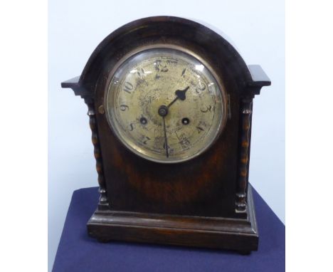 A MANTEL CLOCK WITH 8 DAY STRIKING MOVEMENT AND SILVERED CIRCULAR DIAL, IN OAK CASE WITH LOW DOME TOP AND BOBBIN PILASTERS TO