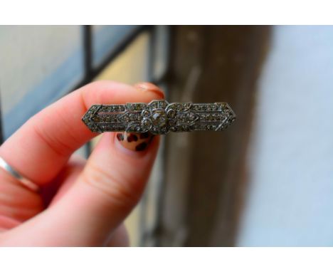Group of jewellery comprising: a platinum set diamond single stone ring, size M, a yellow metal bar brooch with cluster borde