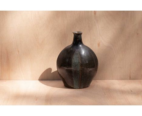 ARR Paul Barron (1917-1983) a stoneware bottle vase of compressed form in tenmoku glaze with white mottled glaze line decorat