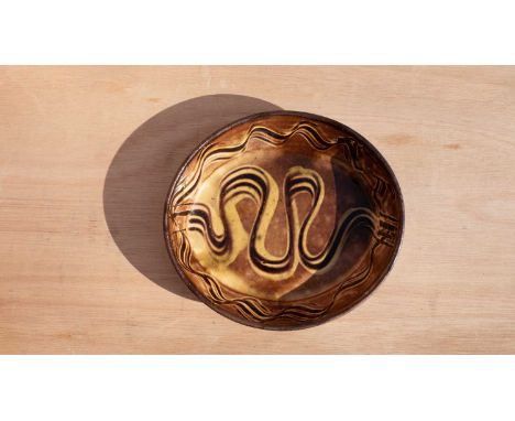 Winchcombe Pottery, a slipware oval dish in yellow and brown glazes with wavy motif decoration to centre and border, impresse