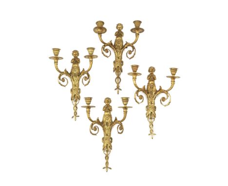 A set of four gilt bronze twin-light wall appliques in the Louis XVI styleeach cast with central figure of a putti playing pa
