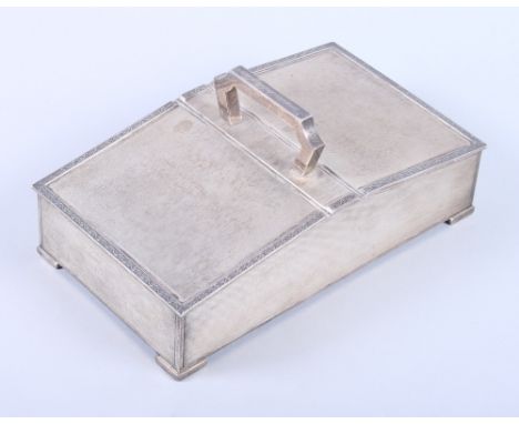 A George V silver two-division cigarette box with engine turned decoration and carrying handle, on bracket feet, 8" long