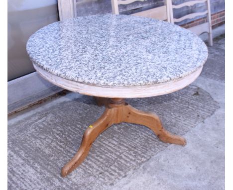 A circular pine dining table with granite top, on tripod splay supports, 43" dia