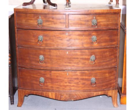 An early 19th century mahogany bowfront chest of two short and three long graduated drawers with lion mask ring handles, on b