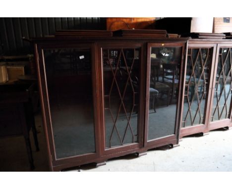 A mahogany bookcase enclosed central lattice glazed door and two plain doors, on bracket feet, 62" wide