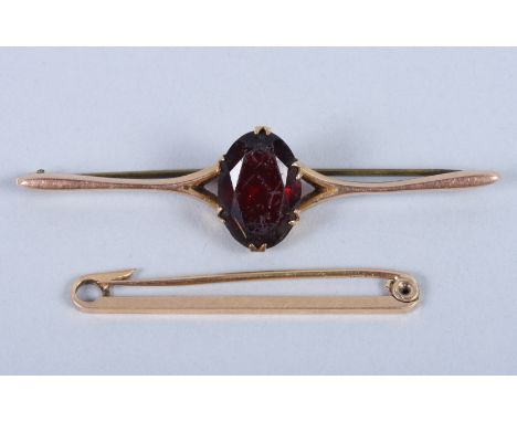 A 15ct gold tie pin and a 9ct gold and red stone brooch