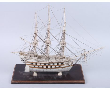 A 19th century Prisoner of War bone scale model of a thirty-two gun two-deck ship, with planked and pinned hull and standing 