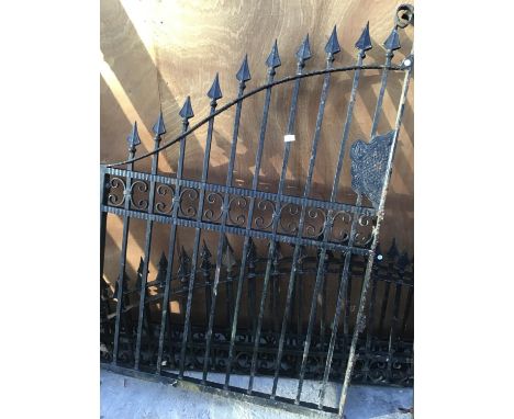 A SINGLE ORNATE WROUGHT IRON GATE AND TWO CURVED FENCE TOP PANELS 