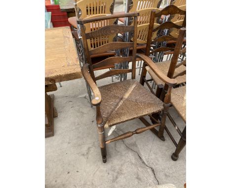 AN OAK LADDER BACK ROCKING CHAIR WITH RUSH SEAT 