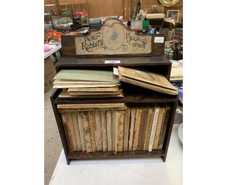 A WOODEN PETER RABBITS BOOK SHELF AND BOOKS 