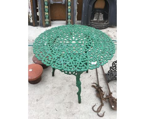 A GREEN PAINTED ORNATE CAST IRON GARDEN TABLE WITH LOWER SHELF 