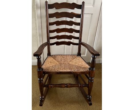 Oak ladder backed rocking chair with rush seat.Condition ReportArm joint loose.