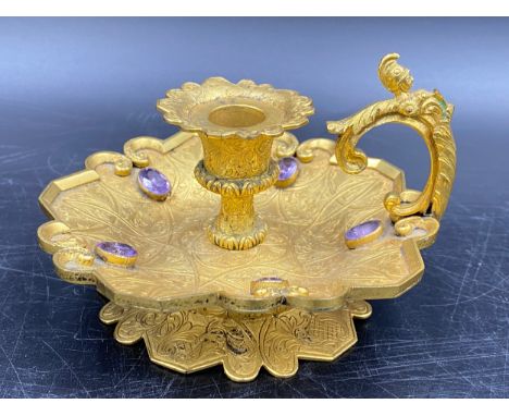 A candlestick holder set with 5 purple coloured stones, centurion head decoration to handle. 11cm w x 6cm h.Condition ReportS