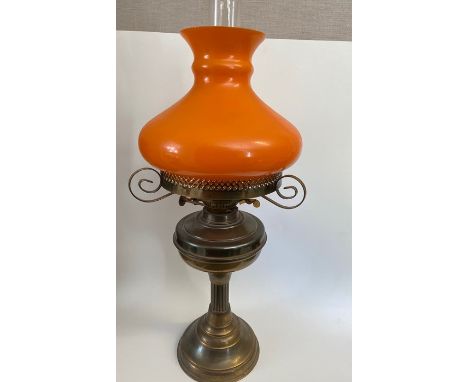 A Duplex copper and brass oil lamp, with a orange glass shade, 57cm tall