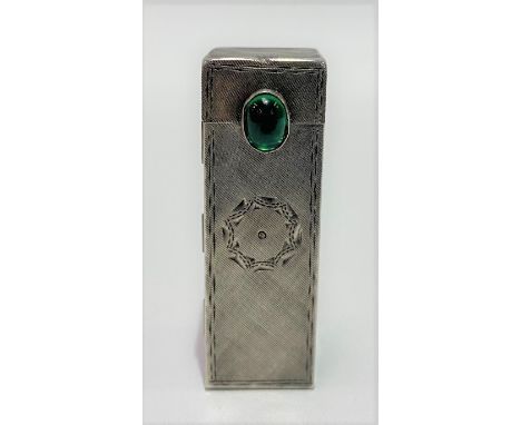 A white metal engine turned lipstick case with sprung mirror and with green glass cabochon button, stamped 800, length 5cm, w