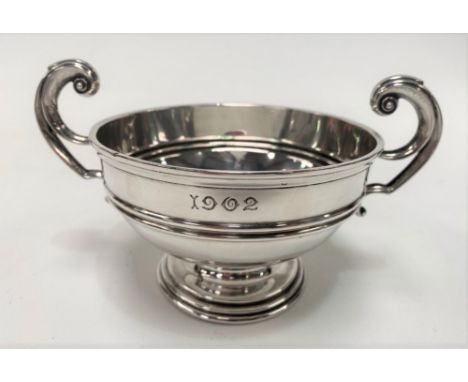 An Edwardian silver twin handled trophy cup by Alstons &amp; Hallam, of pedestal form with flying scroll handles, engraved wi