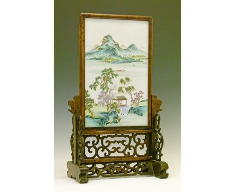 Chinese carved hardwood framed table screen, the rectangular porcelain panel having polychrome decoration depicting a lakelan