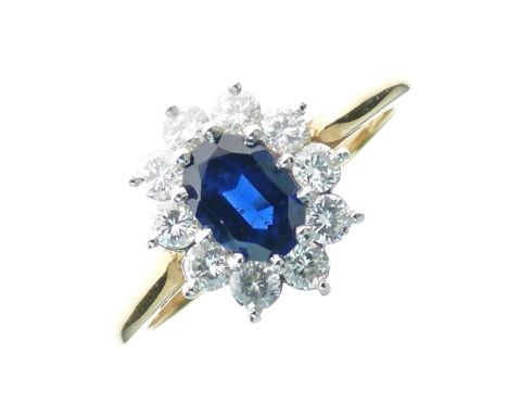 Sapphire and diamond cluster ring, stamped '18ct Plat', the oval cut stone enclosed by ten brilliant cuts totalling approxima