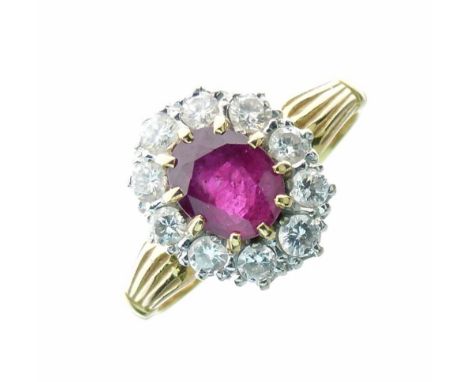 Ruby and diamond 18ct gold cluster ring, the oval cut ruby measuring approximately 7mm x 5.5mm x 3.5mm deep, enclosed by ten 