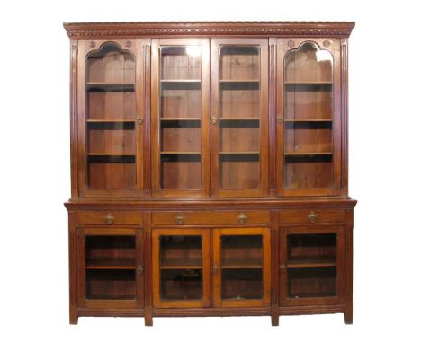 Victorian walnut Gothic design two section library bookcase, the upper section having a moulded and carved cornice, four glaz