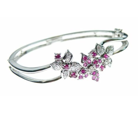 Diamond and ruby hinged bangle, tagged 'Jewel Mine 750', the flower head frontispiece set with nineteen rubies and twenty sma