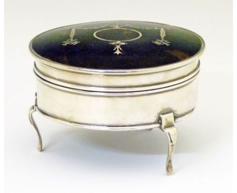 George V silver and tortoiseshell circular trinket box having inlaid ribbon and swag decoration and standing on triple splaye