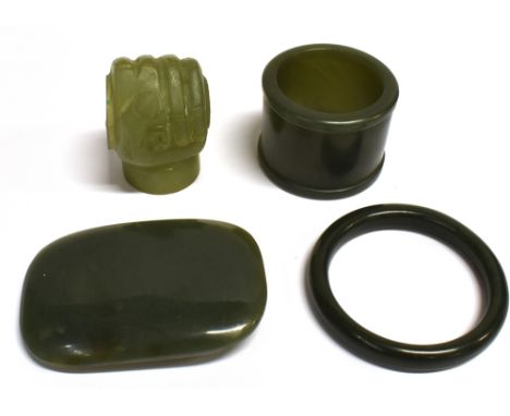 FOUR CHINESE JADE/JADEITE ITEMS  including a buckle 7cm wide, an L-shaped bracket modelled as a clenched fist, diameter of ea